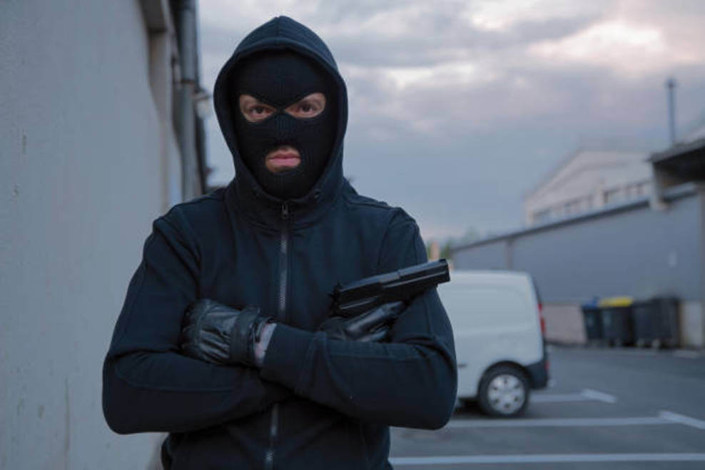 A person looking like a robber with a pistol in hand