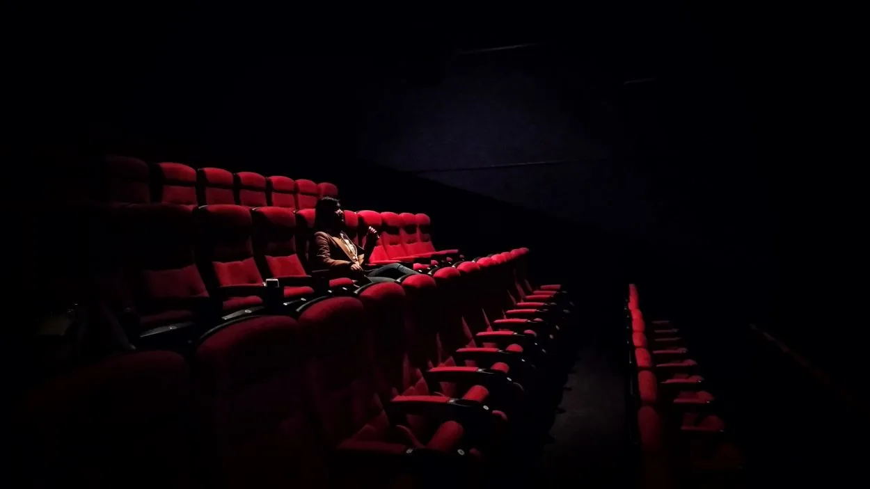 A person is sitting in a theater alone