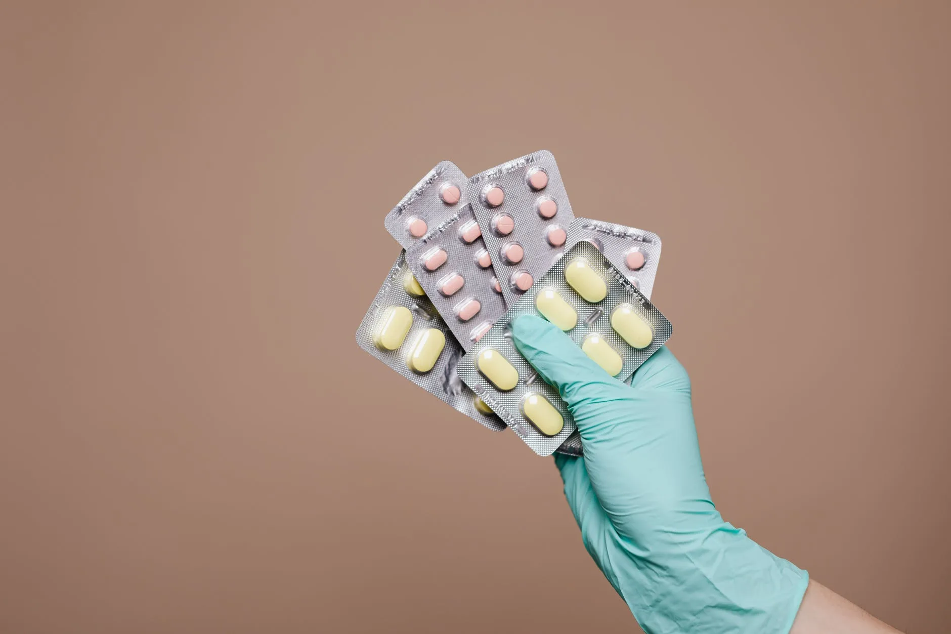A person holding up different pills