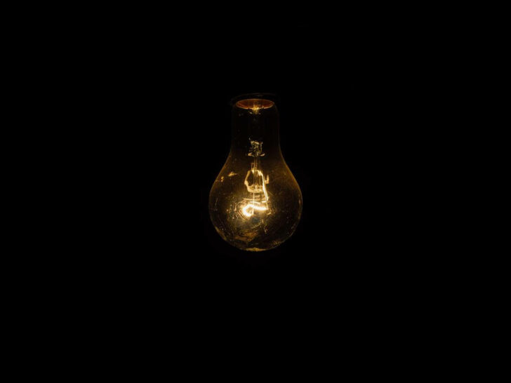 A close-up of filament glowing in a light bulb.