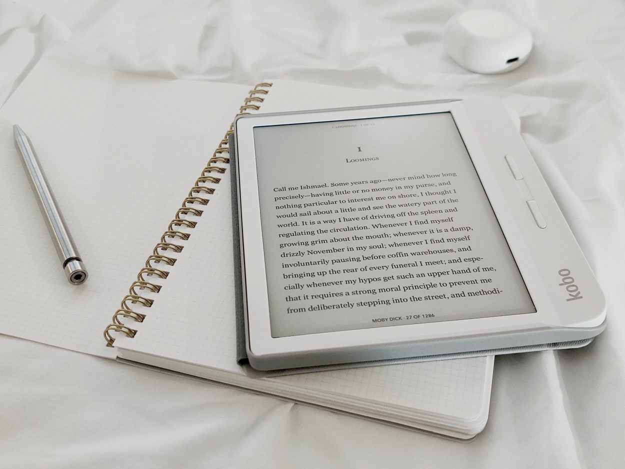 A kindle on top of a notebook