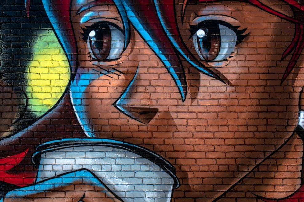 An anime picture on a brick wall
