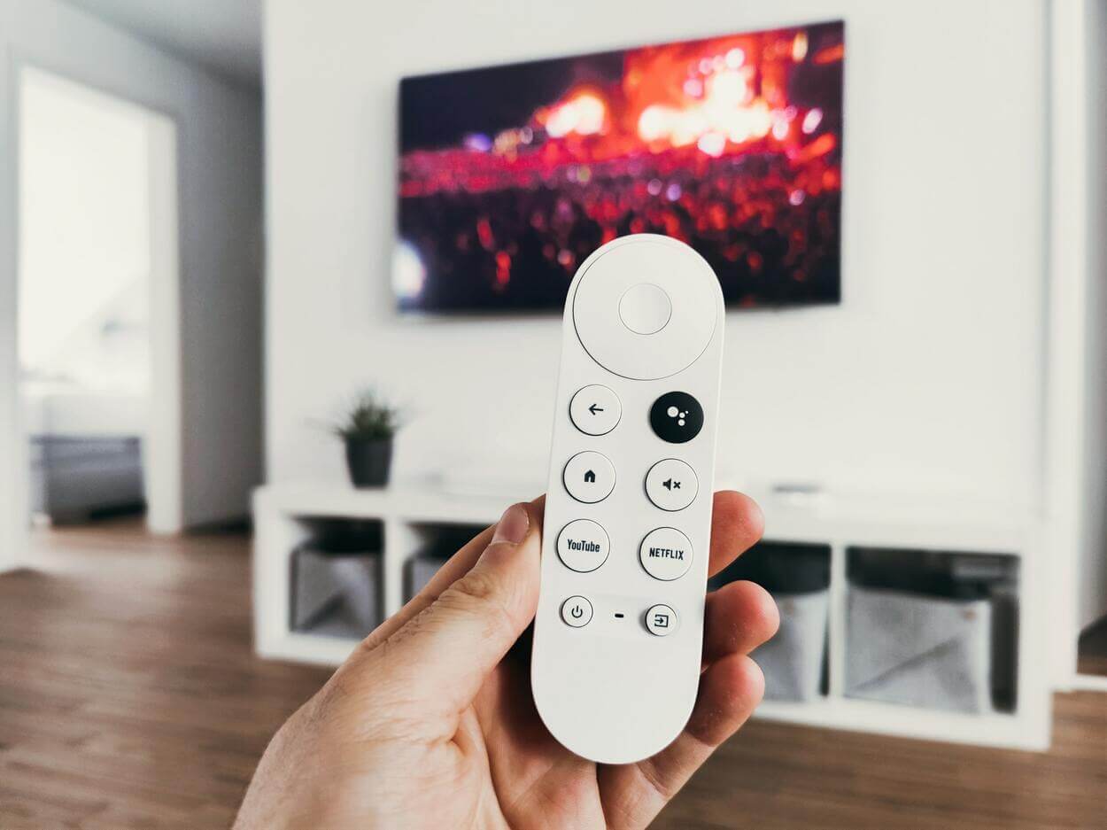 Hand holding a remote for UHD TV.