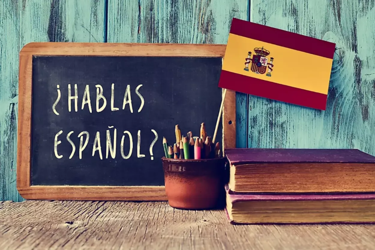 A black slate board shoeing a phrase of Spanish