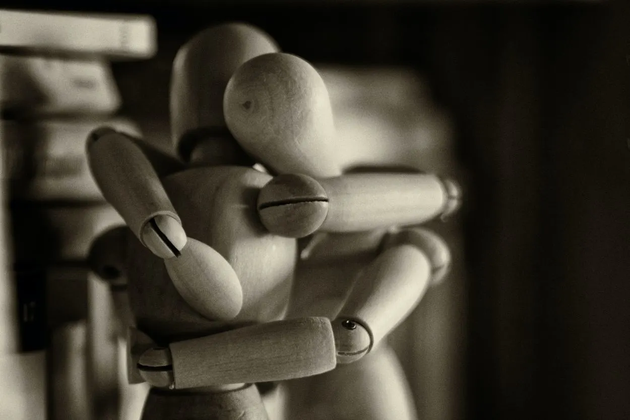 Two wooden figures hugging