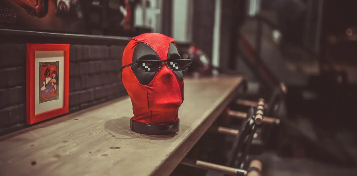 A toy head of Deadpool with glasses