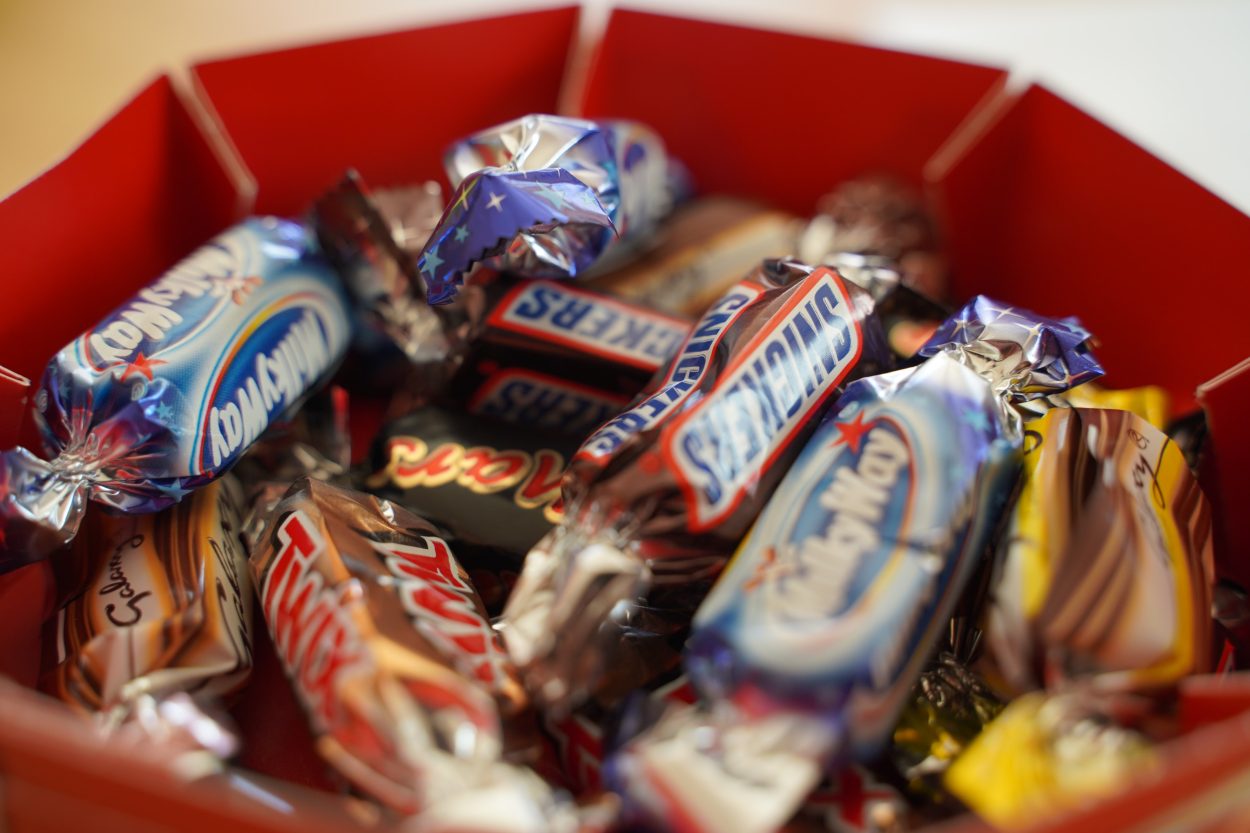 A bucket filled with different chocolate bars including Twix bar.