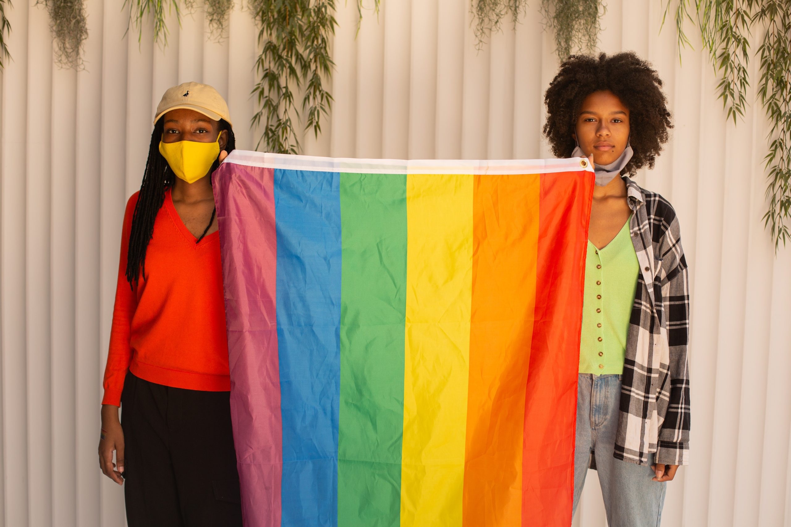 Two people holding the LGBT flag up
