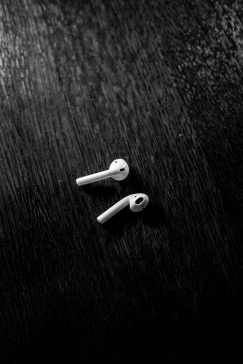 A photograph of ear pods placed against a black background