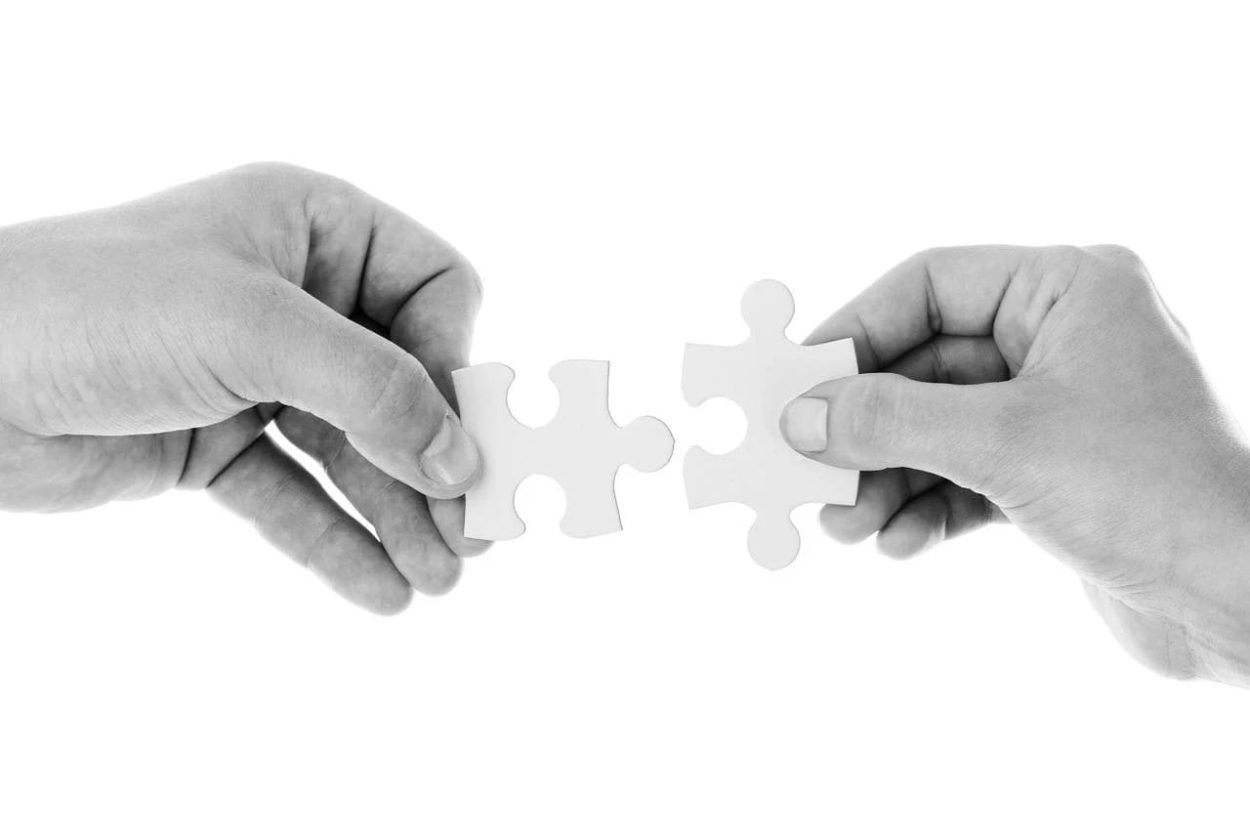 Image of hands holding two puzzle pieces.