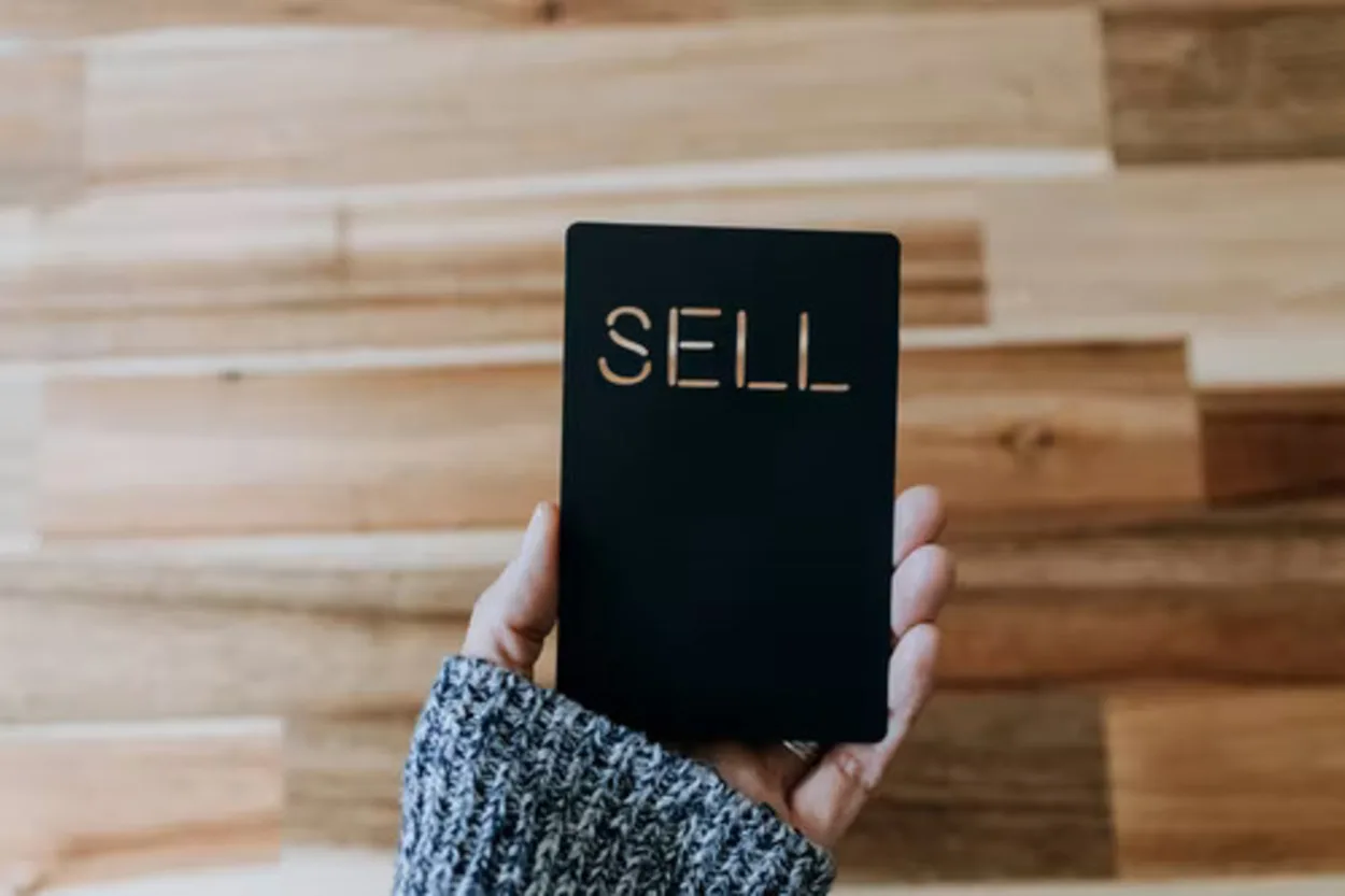 a person holding a card that says sale