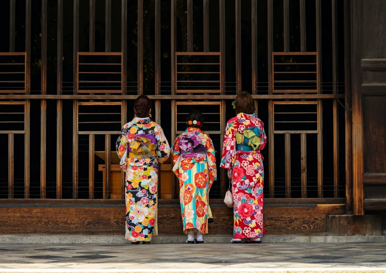Three women standing with their backs wearing Wafuku/Kimono