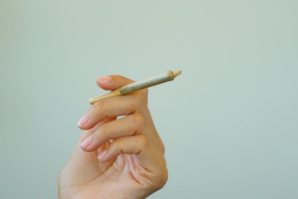 An image showing a person holding a joint.