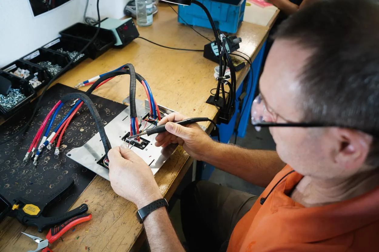 A man soldering cables.
