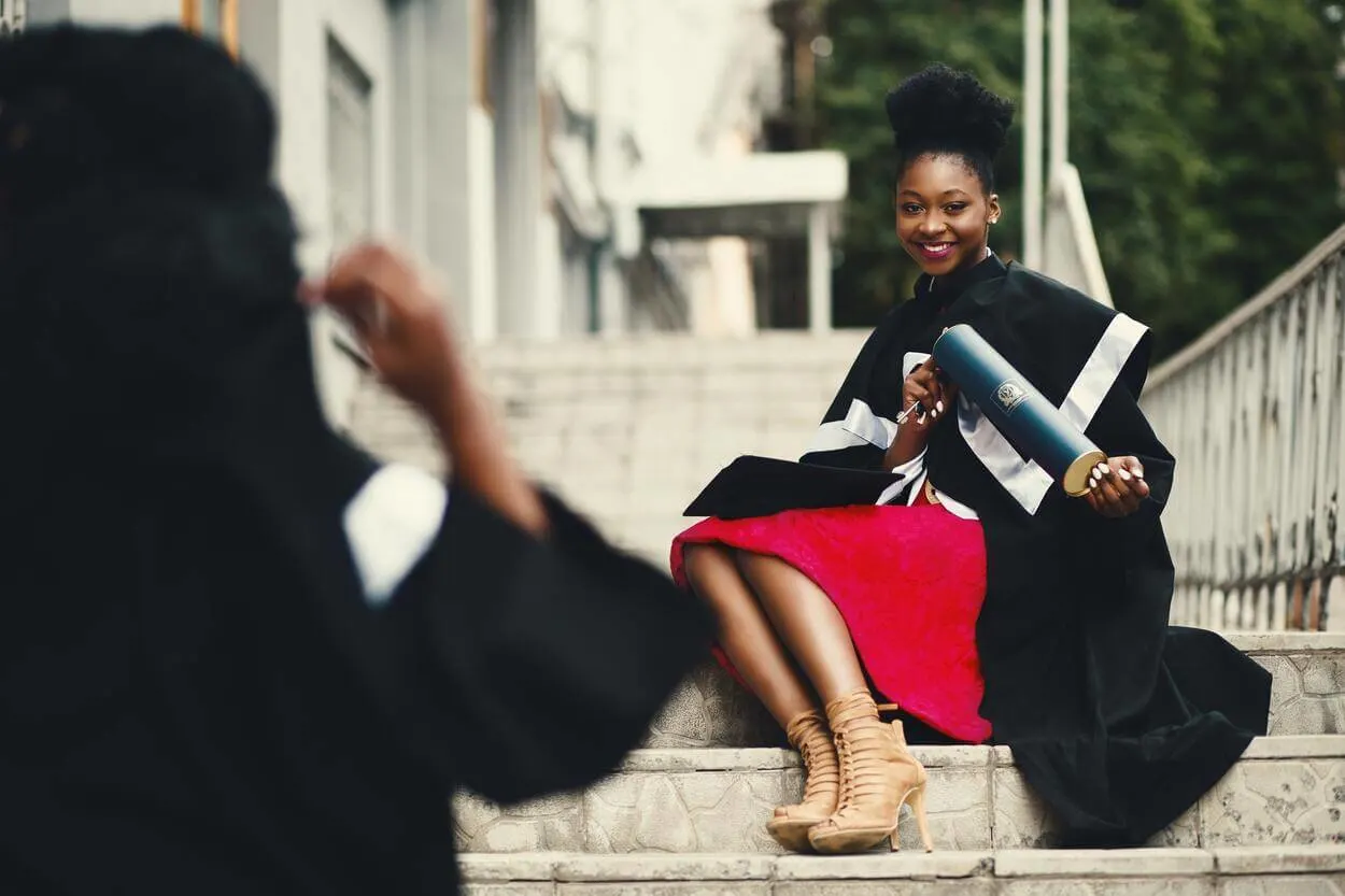 An image of student posing fir a photograph after receiving her degree.