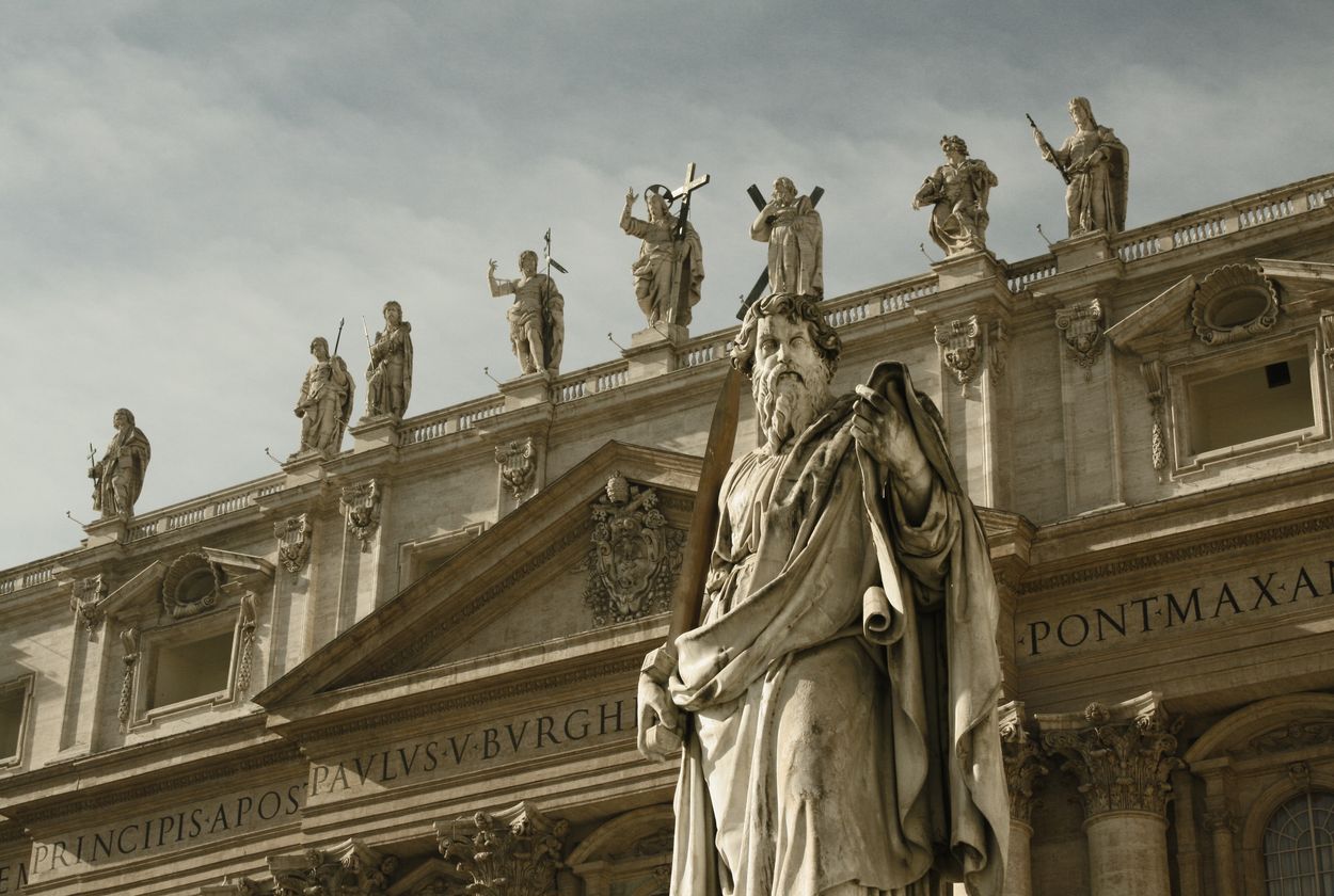a statue of a roman philosopher in front of a building