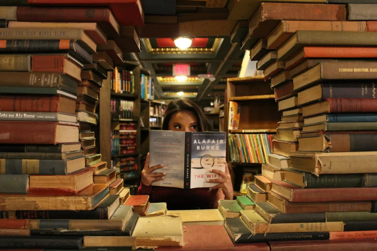 a person with a book surrounded by books
