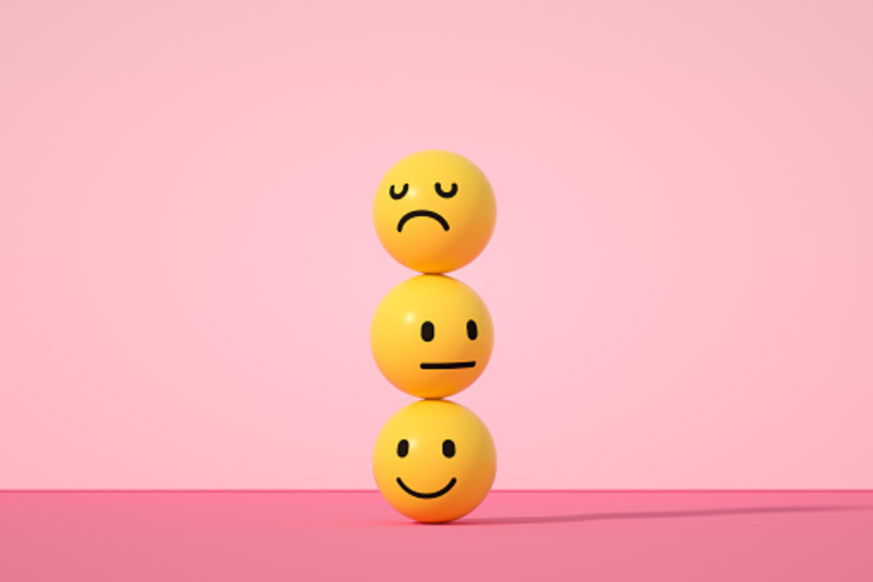 3-D emoji faces stacked against a pink background