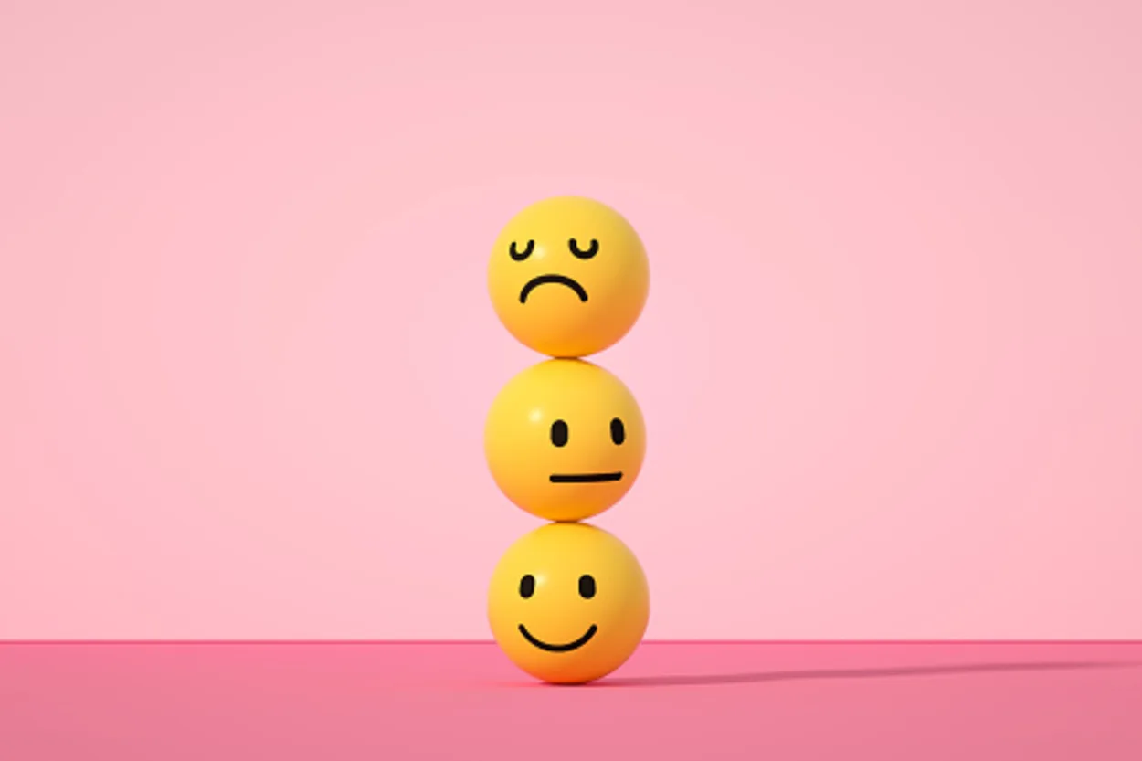 3-D emoji faces stacked against a pink background