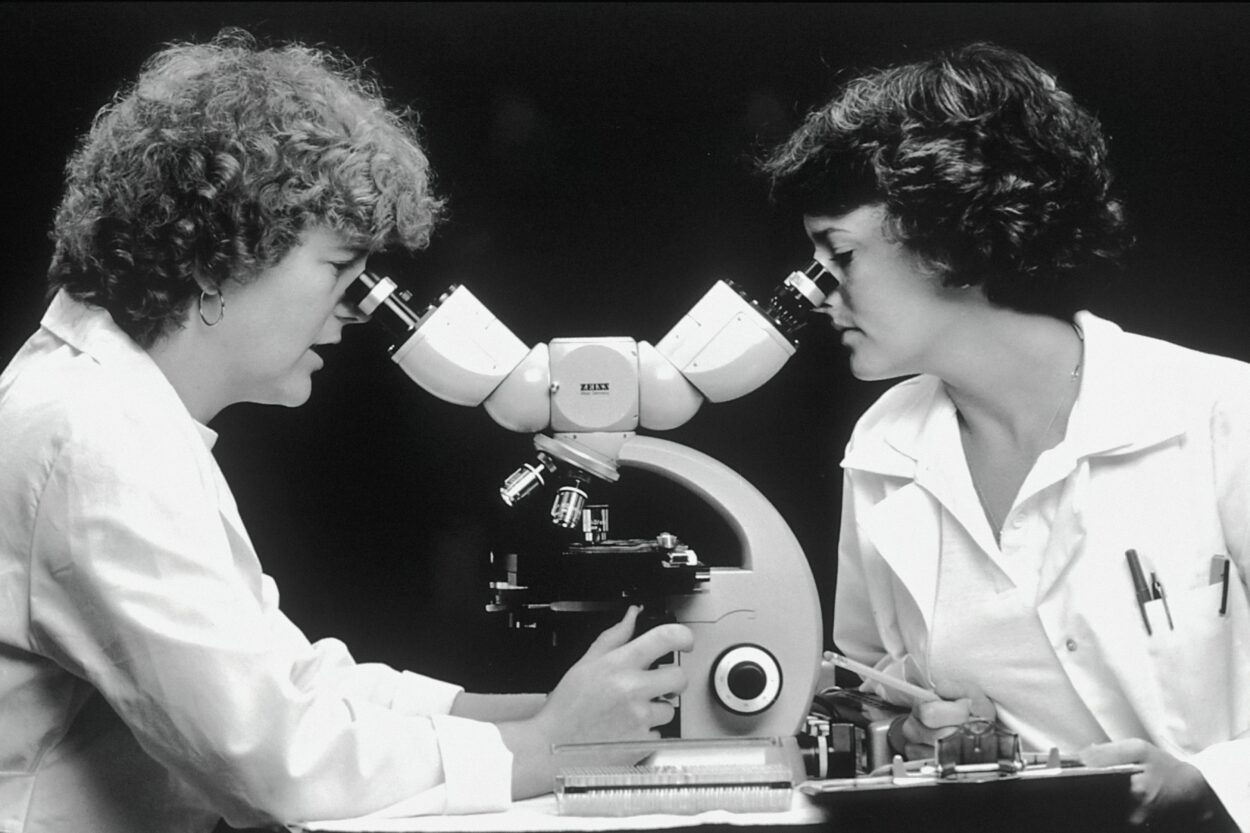 two scientists looking through a microscope