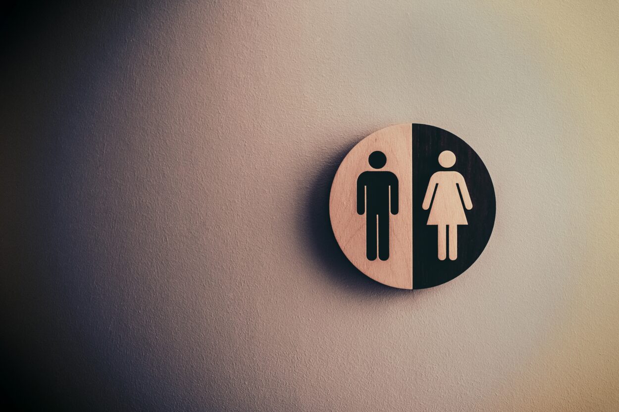 the common male and female sign on a wooden circle
