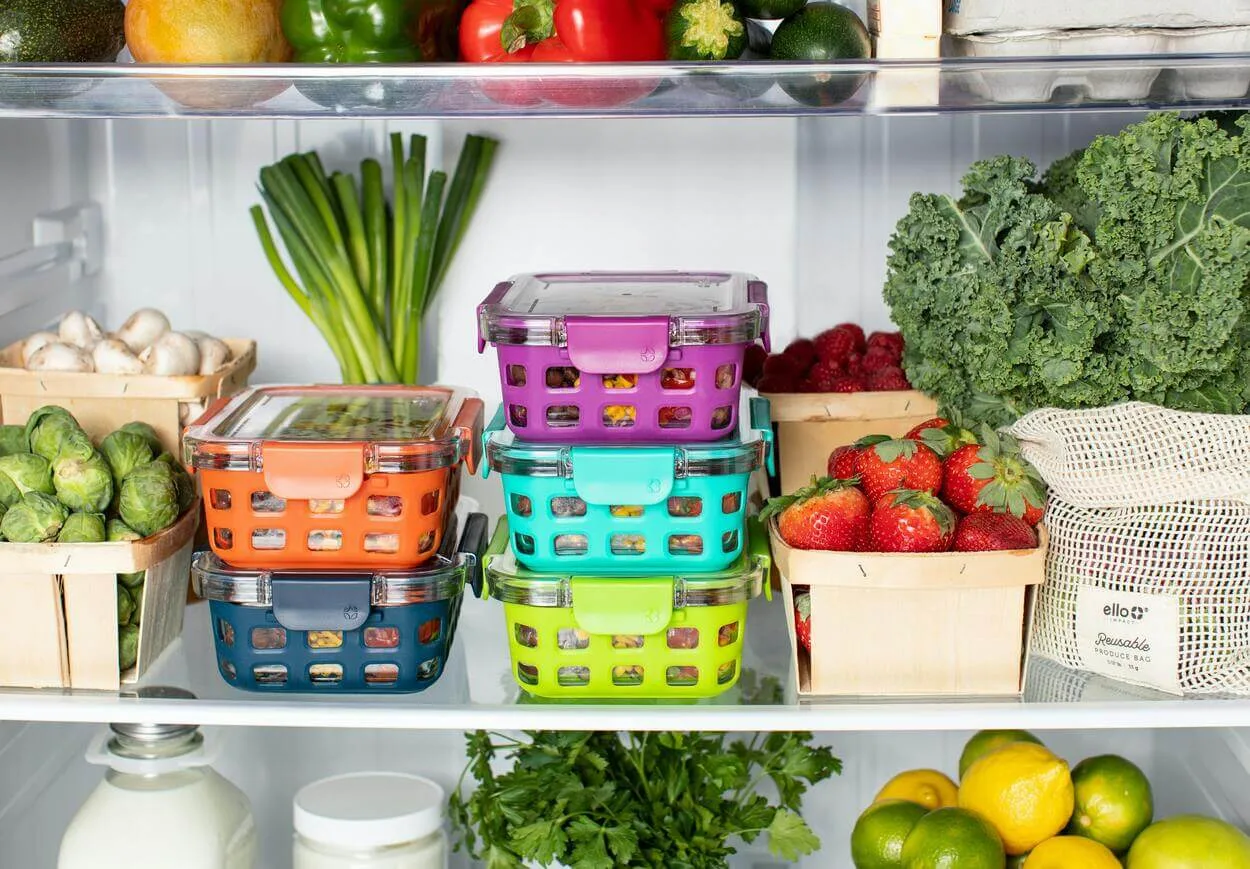 An image of vegetables and fruits in fridge compartments.