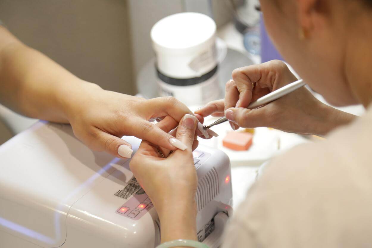 An image of a woman getting her nails done in a salon.