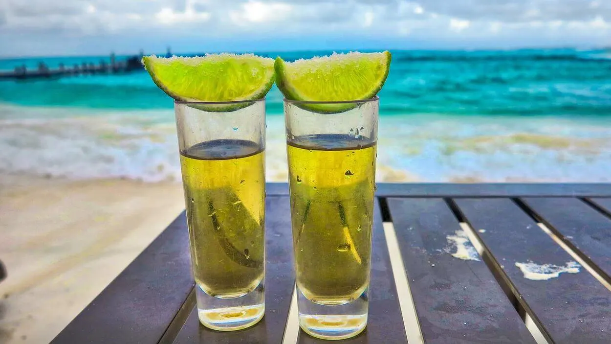 An image of two shot glasses with lime.