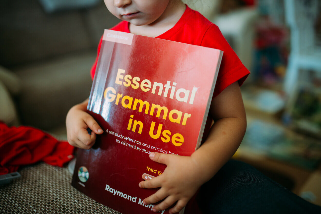 An image of a grammar book in the hand of a child.