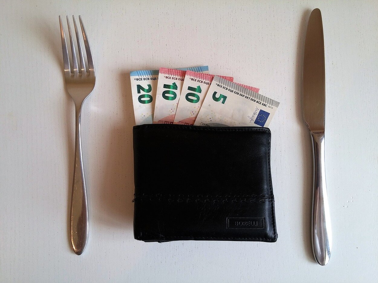 An image of forks and knife along with bill and tip money.