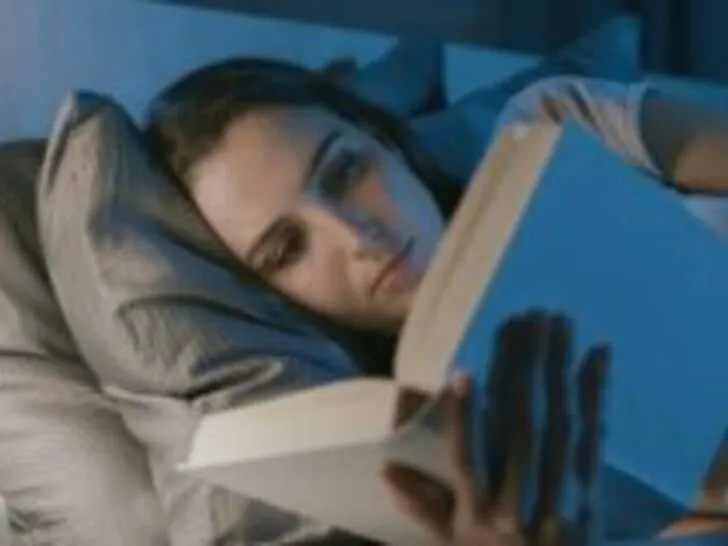 girl reading book while laying