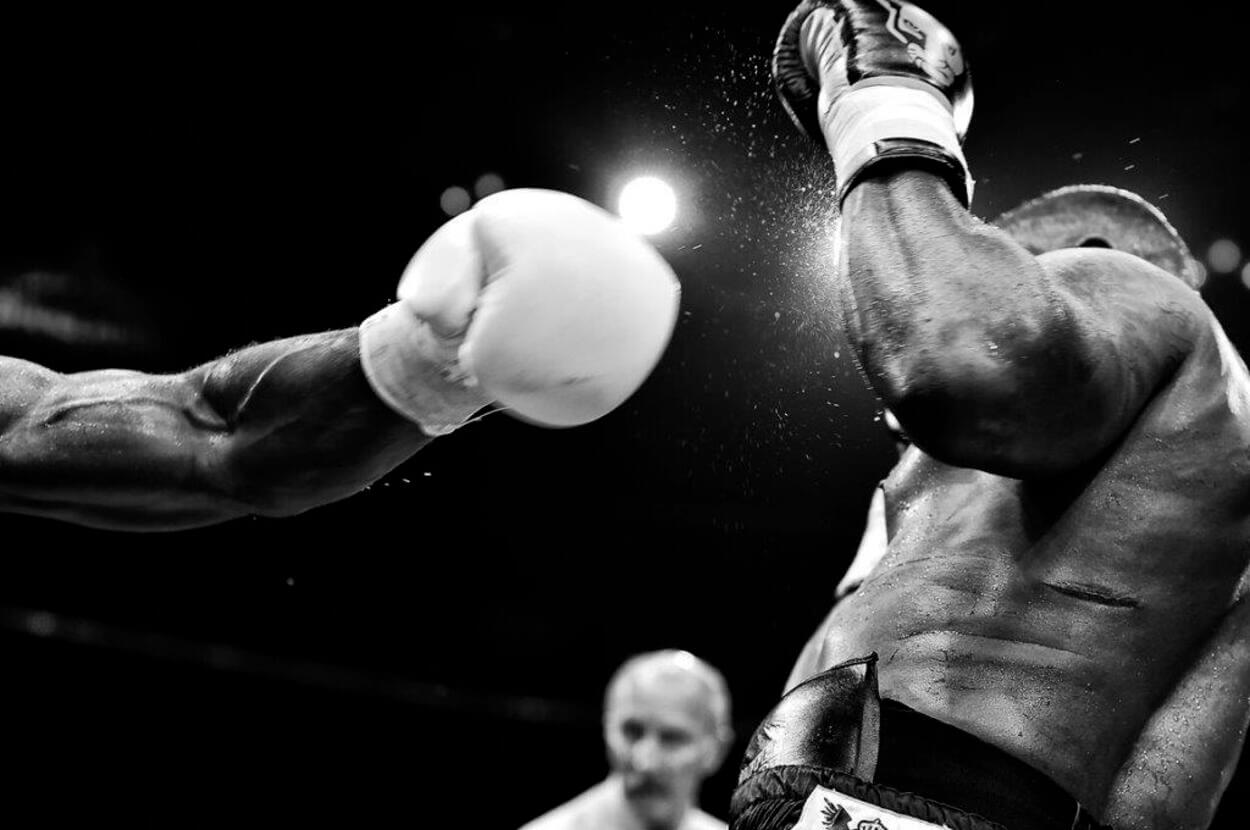 Image of a boxer getting hit by his opponent.