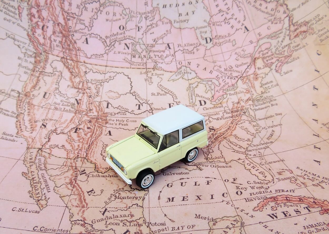 Image of a map showing different states and a toy car is placed over it.