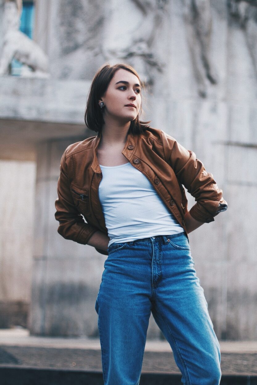 Woman wearing Short brown leather jacket.